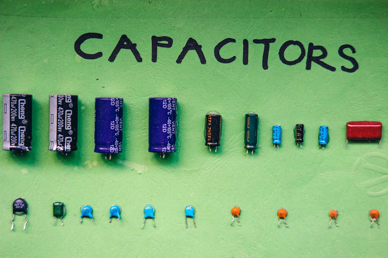 gallery-5 Top view layout of various capacitors for storing electrical energy of different sizes and capacities arranged on green background with inscription